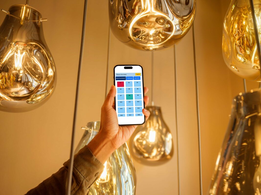 mockuuups male hand holding a iphone mockup in the lounge refacuta scaled 1